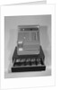 Cash register with money in the open till drawer by Anonymous