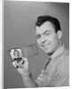 Smiling man holding up wallet with picture of wife and daughter by Anonymous