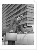 Businessman carrying briefcase getting into car on urban street by Anonymous