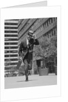 Businessman carrying briefcase holding his hat on running down urban sidewalk by Anonymous