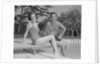 Man woman couple sitting on diving board on side of swimming pool by Anonymous