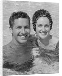 Smiling couple man woman in swimming pool by Anonymous