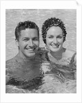 Smiling couple man woman in swimming pool by Anonymous