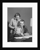 Couple man seated at desk holding paper woman standing looking over his shoulder smiling happy by Anonymous