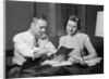 Couple man woman smiling looking at banking savings passbook at home desk by Anonymous