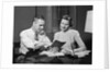 Couple man woman smiling looking at banking savings passbook at home desk by Anonymous
