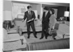 Furniture store salesman talking to couple by Anonymous
