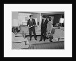 Furniture store salesman talking to couple by Anonymous