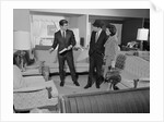 Furniture store salesman talking to couple by Anonymous