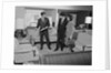 Furniture store salesman talking to couple by Anonymous