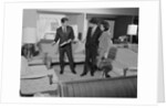 Furniture store salesman talking to couple by Anonymous