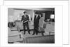 Furniture store salesman talking to couple by Anonymous