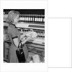 Blond woman selecting ice cream frozen food section supermarket by Anonymous