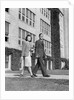 College couple walking on campus before ivy covered building by Anonymous