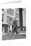 College couple walking on campus before ivy covered building by Anonymous