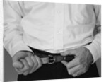 Man hands tightening belt by Anonymous
