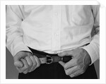 Man hands tightening belt by Anonymous