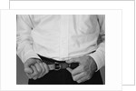 Man hands tightening belt by Anonymous