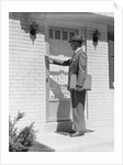 Salesman wearing suit tie hat carrying briefcase ringing suburban house doorbell by Anonymous