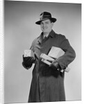 Man wearing winter coat hat gloves holding packages parcels by Anonymous
