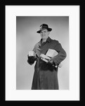 Man wearing winter coat hat gloves holding packages parcels by Anonymous