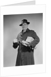 Man wearing winter coat hat gloves holding packages parcels by Anonymous