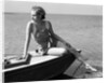 Woman wearing one piece bathing suit sitting on edge of boat by Anonymous