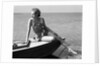 Woman wearing one piece bathing suit sitting on edge of boat by Anonymous