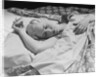 Sleeping blond woman hand over head asleep by Anonymous