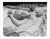 Sleeping blond woman hand over head asleep by Anonymous