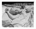 Sleeping blond woman hand over head asleep by Anonymous
