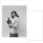 Smiling brunette teen student wearing sweater carrying school books by Anonymous