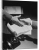 Close-up two male hands about to shake over desk with papers and telephone by Anonymous