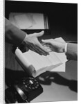 Close-up two male hands about to shake over desk with papers and telephone by Anonymous