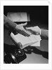 Close-up two male hands about to shake over desk with papers and telephone by Anonymous