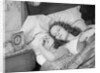 Woman sleeping asleep in bed alarm clock on night table by Anonymous