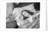 Woman sleeping asleep in bed alarm clock on night table by Anonymous