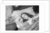 Woman sleeping asleep in bed alarm clock on night table by Anonymous