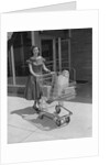 Smiling woman pushing grocery cart out of supermarket by Anonymous