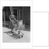 Smiling woman pushing grocery cart out of supermarket by Anonymous