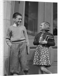 Smiling boy & girl holding school books by doors by Anonymous
