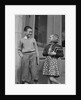 Smiling boy & girl holding school books by doors by Anonymous