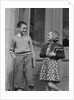 Smiling boy & girl holding school books by doors by Anonymous