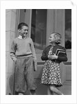 Smiling boy & girl holding school books by doors by Anonymous