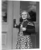 Smiling girl print dress holding school books opening door by Anonymous