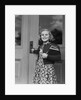 Smiling girl print dress holding school books opening door by Anonymous