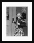 Smiling girl print dress holding school books opening door by Anonymous