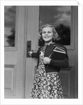 Smiling girl print dress holding school books opening door by Anonymous