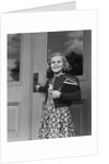 Smiling girl print dress holding school books opening door by Anonymous