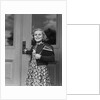 Smiling girl print dress holding school books opening door by Anonymous